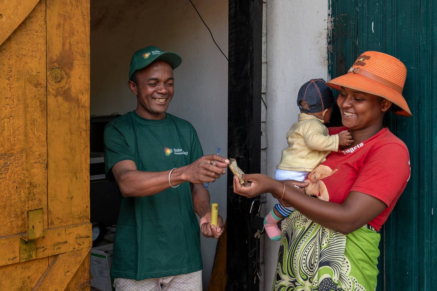 Franchisee Delson giving out a solar battery to a community member