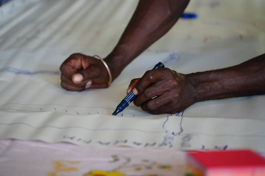 Close up of male participant's hands writing_drawing on the community_resources map.jpeg
