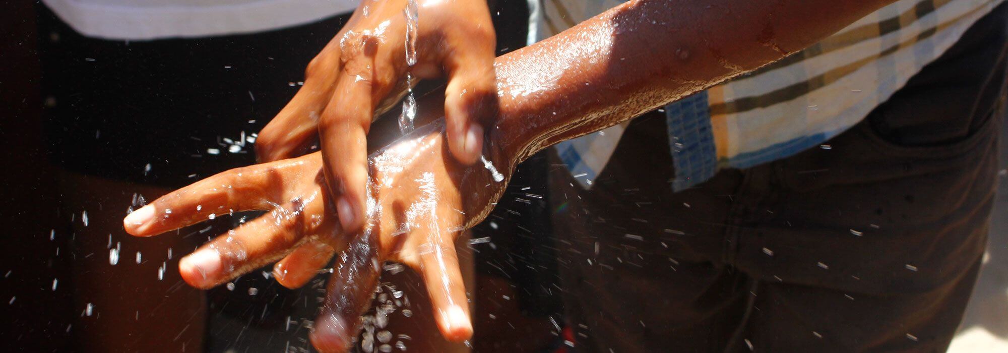 A young man washing his hands with water and soap