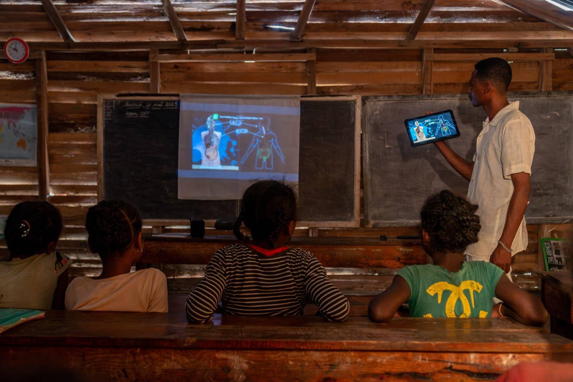 Teacher and students using a tablet and projector