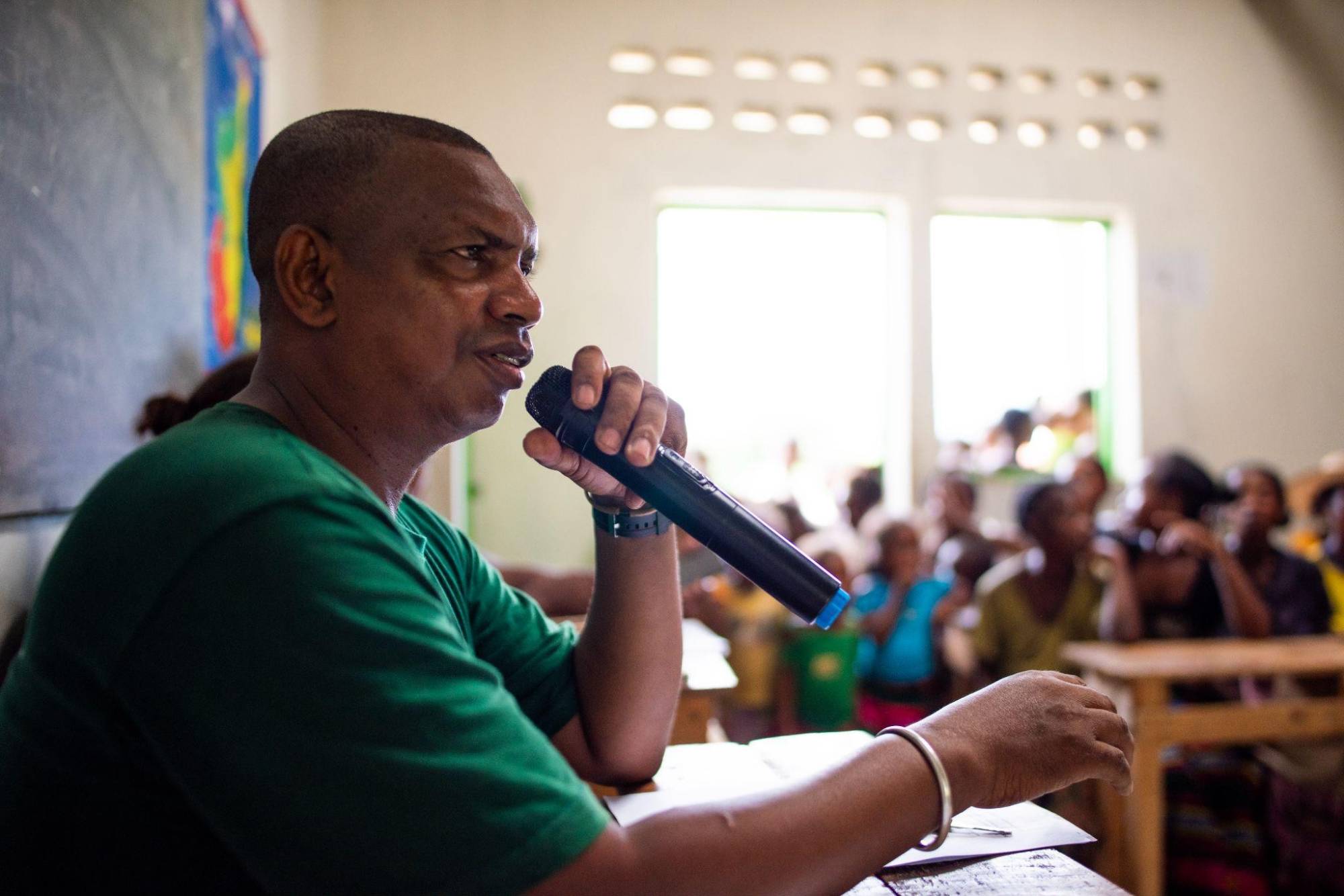 Theo speaks into a microphone at a meeting