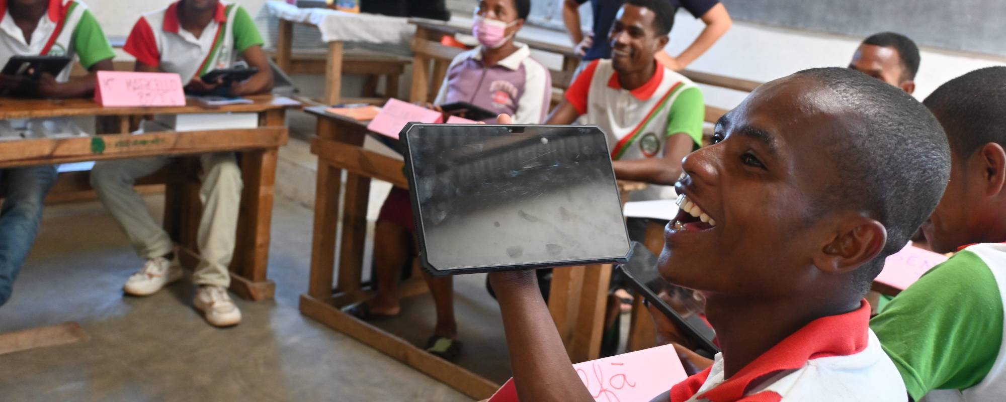 Teacher smiling while holding a digital tablet