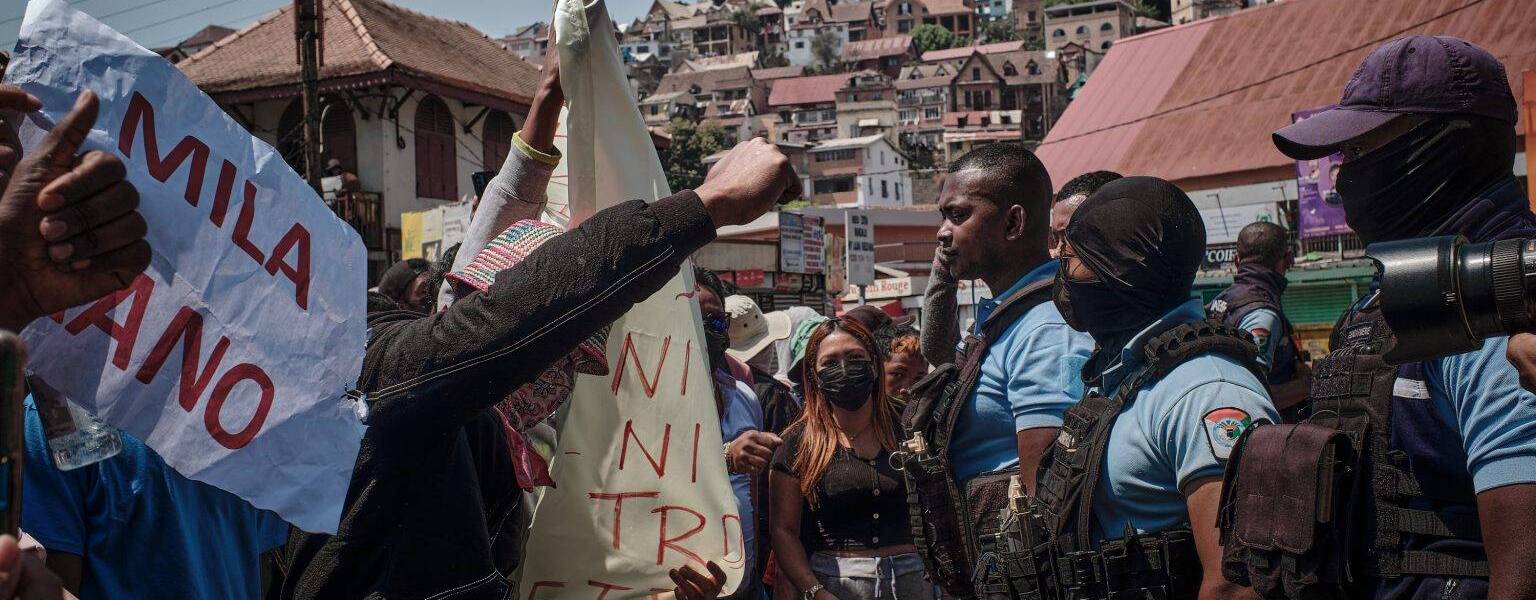 Demonstrators standing in front of the police, waving banners